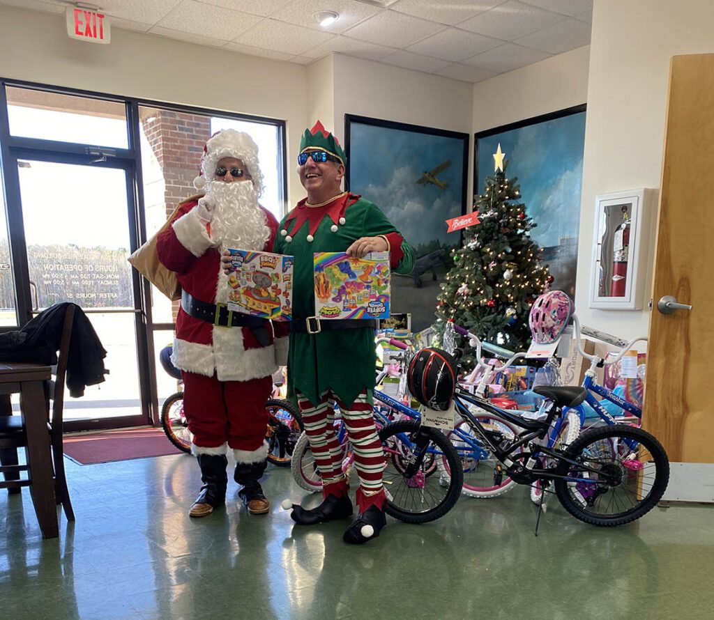 Santa and Elf Showing Off Swag For Toy Drive